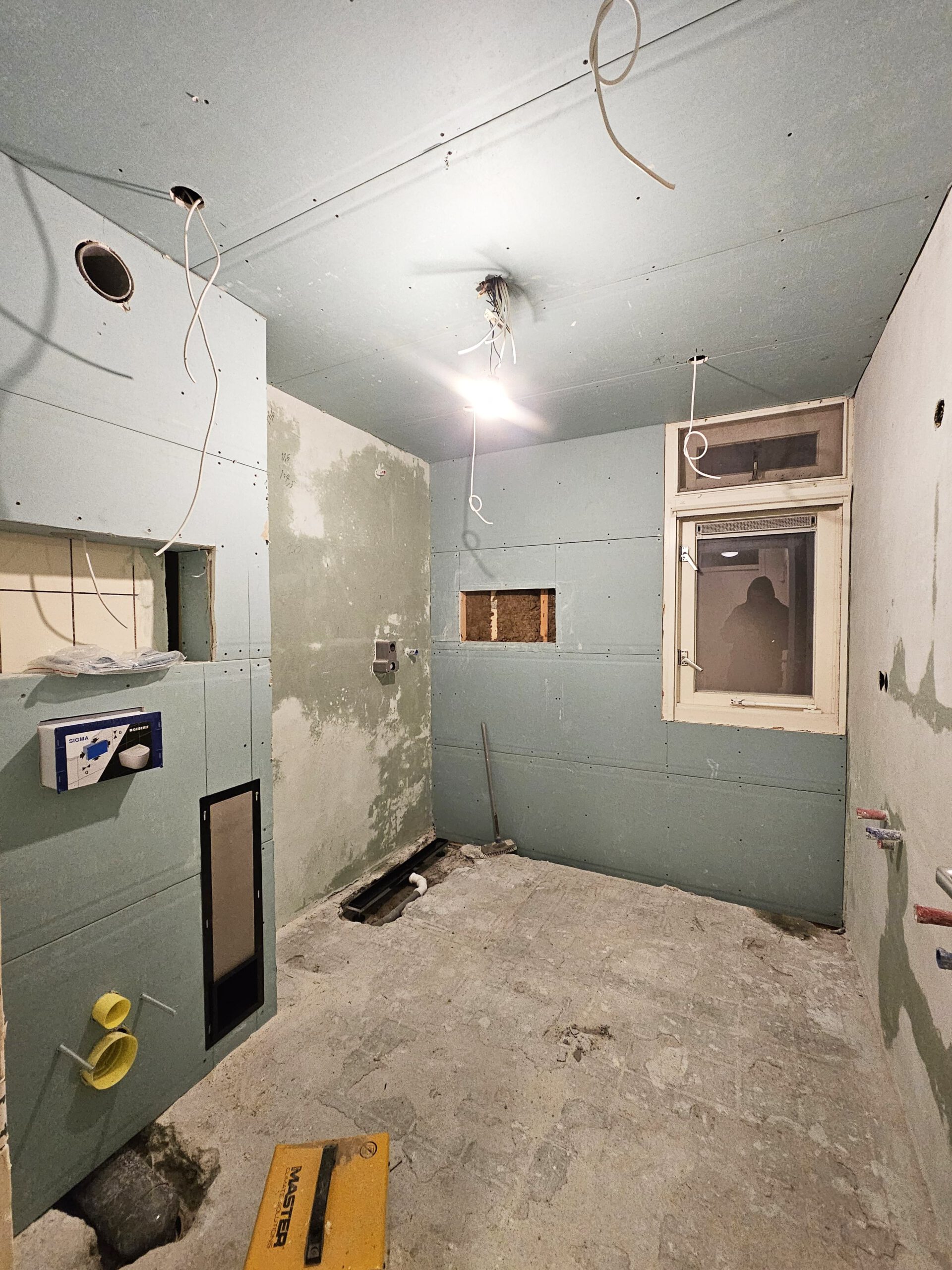 Badkamer tijdens de renovatie, volledig gestript tot op de muren